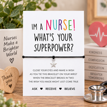 A wish string bracelet with presentation card with the text 'I'm a NURSE! WHAT'S YOUR SUPERPOWER?' tied with a black bracelet and a small silver star charm. Gift for a nurse.