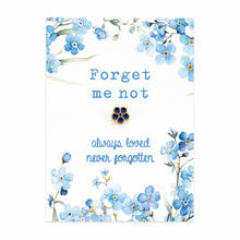 A small flower-shaped earring with dark blue inlay and gold-tone edges, displayed on a white card with blue forget-me-not flowers and the text 'Forget me not' and 'always loved never forgotten'.