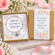 Personalised Thank you for being our flower girl charm bangle. A silver charm bracelet presented in a floral gift box. The bracelet has a round silver bracelet with a flower charm, a small pearl bead, and a round initial charm. Flower girl gift.