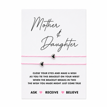 A Mother & Daughter bracelet gift set on a white card. The set includes two delicate pink cord bracelets, each with a small silver heart charm, displayed on a clean white background.
