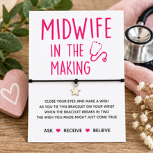 A midwife-themed bracelet set featuring a black cord bracelet with a small silver star charm. The white card has pink and black text reading 'MIDWIFE IN THE MAKING' student midwife gift