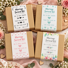 A Kraft brown gift box with a floral wedding-themed label reading 'Marriage Survival Kit' and personalised bride and groom names with  the date of the wedding. Customised wedding gift. Unusual wedding present. Personalised marriage survival kit 