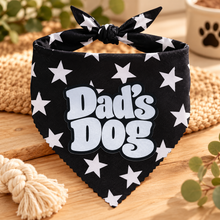 A black and white star print pet bandana with a tie-neck loop, featuring the text 'Dad's Dog' in white bubble letters with a black outline. Dads dog bandana. Funny slogan dog scarf tie on adjustable.