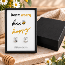 Sterling silver bee stud earrings displayed on a white card inside a black gift box that reads 'Don't worry bee happy' with 'STERLING SILVER'. Don’t worry bee happy bee earrings gift set.