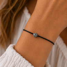 striped wish string bracelet. Black and white striped bead on a black cord bracelet.