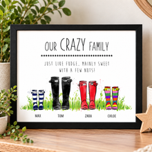 A framed personalised art print featuring colourful illustrated rain boots labeled for family members Max, Tom, Zara, and Chloe, with the text 'OUR CRAZY FAMILY' and a playful quote. Customised family welly boots print.