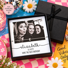 A personalised sterling silver necklace with an initial 'E' pendant, presented in a black gift box with a photo of three women and the text 'elizabeth IS FIFTY HAVE THE BEST BIRTHDAY'. Silver black and white picture necklace 