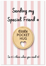 Pocket hug in the post for a special friend. A wooden round pocket hug token with a heart-shaped cutout, displayed on a pink and white striped card that reads 'Sending my Special Friend a little POCKET HUG So it's there when you need it!'.