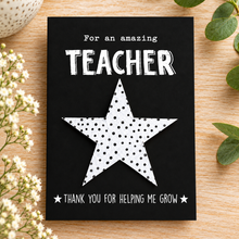 Teaching assistant wildflower seeds gift. A black greeting card with white text reading 'For an amazing TEACHER' and 'THANK YOU FOR HELPING ME GROW,' featuring a large polka dot plantable seeds star in the centre. Gift for teacher. THank you teacher 