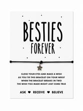 A black cord bracelet with a small star charm displayed on a white card that reads 'BESTIES FOREVER' with additional wish instructions text below. Gift for your bestie.