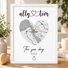 Customised engagement gift. A framed personalised map print on a white background, featuring a heart-shaped Liverpool map with the names 'ally' and 'tom' at the top and 'The yes day' with a date and ring icon below.