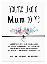 A close-fitting black cord bracelet with a small silver heart charm, displayed on a white card that reads 'You're Like a Mum to Me' with a floral illustration and a wish blessing tied on the bracelet. Like a mum to me wish bracelet. Gift for stepmother bonus mom. 