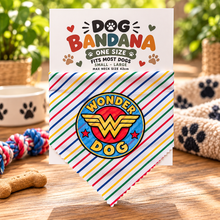 A dog bandana with a colourful Wonder Dog logo, displayed in front of its white packaging card. Wonder dog bandana in striped print. Superhero dog bandana. Funny slogan dog scarf neck tie
