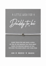 Daddy to be wish string bracelet.  A grey card with white text that reads 'A LITTLE WISH FOR A Daddy to be' tied with a thin white string and a small star charm, displayed against a white background. Daddy to be gift 