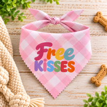 Pink and white gingham check dog bandana with a tie-neck bow, featuring the text 'Free KISSES' in colourful bubble letters. Cute puppy accessory