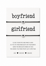 A white rectangular card with black text reading 'boyfriend' and 'girlfriend' above two matching cord bracelets with small heart charms. Boyfriend girlfriend proposal. Anniversary card filler gift.