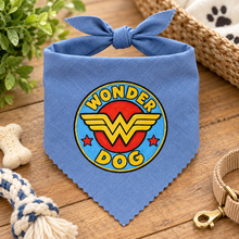 A blue dog bandana with a knotted top edge and a circular 'Wonder Dog' graphic on the front,. Wonder dog bandana in blue. Superhero dog bandana. Funny slogan dog scarf neck tie
