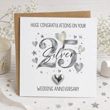 A white  and silver 25th wedding anniversary greeting card with a kraft envelope