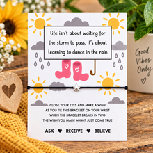 Dance in the rain wish string bracelet. A small silver star charm on a black cotton cord bracelet with an empowerment card that reads LIFE ISN’T ABOUT WAITING FOR THE STORM TO PASS IT’S ABOUT LEARNING TO DANCE IN THE RAIN. Wish instructions included.