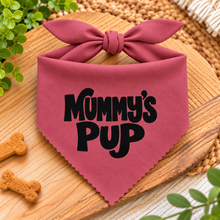 A dusky pink pet bandana with a bow on top, featuring the text 'Mummy's Pup' in black. Mummys pup adjustable dog bandana. Mums puppy dog scarf in pink and white check. Tie on dog neck tie.