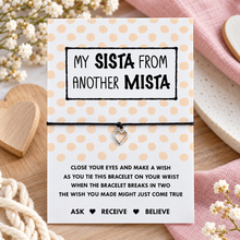 Sista wish string bracelet. A black cord bracelet with a small silver heart charm displayed on a white card with peach polka dots. The card reads 'MY SISTA FROM ANOTHER MISTA' and includes a wish blessing message. Gift for best friend. 