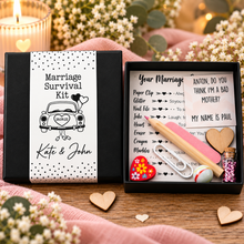 A black gift box with a white paper label reading 'Marriage Survival Kit' and personalised text 'Kate & John' with a car illustration. Unusual wedding gift. Customised wedding present 