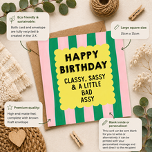 A square birthday card with pink and green vertical stripes and a yellow scalloped center panel reading “HAPPY BIRTHDAY CLASSY, SASSY & A LITTLE BAD ASSY,” styled on a kraft envelope with decorative dried flowers, twine, and text callouts about sustainability, size, and personalization.