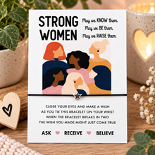 Strong women wish string bracelet. A square white card with the words “STRONG WOMEN” and an illustrated group of women, with a black cotton cord bracelet with a silver star charm. The card includes a blessing and the phrases “ASK ♥ RECEIVE ♥ BELIEVE.