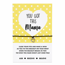 A yellow and white polka dot card with a message for 'You Got This Mama' tied with a black cord and a small silver heart-shaped charm. Gift for a new mum.