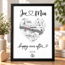 A framed personalised map print of London with a heart-shaped street layout, the names 'Joe' and 'Mia' at the top, and 'happy ever after' with a date and wedding rings below. Customised wedding print gift