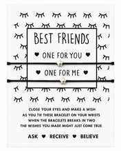 Gift for best friend - BFF bracelets. A white rectangular card with black printed text and line art, featuring two black cord bracelets with small silver star charms laid across the centre. The card reads 'BEST FRIENDS' and 'ONE FOR YOU' and 'ONE FOR ME,' with additional wish instructions below.