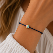 Rainbow wish bracelet. A small rainbow striped bead on a black cotton cord bracelet.