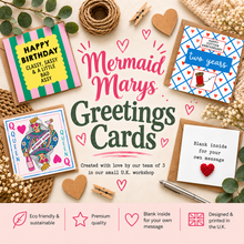 A styled flat-lay of handmade greeting cards with mermaid and queen-themed designs, surrounded by eucalyptus leaves, wooden hearts, twine, and a pen on a cream background. The central text reads 'Mermaid Marys Greetings Cards'.