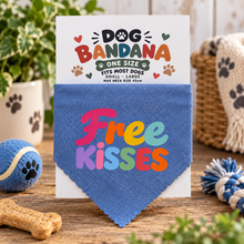 Blue free kisses dog bandana. Slogan dog neck chief. A blue fabric dog bandana with the words 'Free Kisses' in colourful letters, displayed on a branded backing card. The card reads 'DOG BANDANA ONE SIZE' and includes paw-print graphics.ef. 