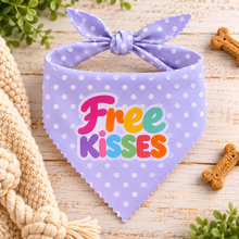 A lavender pet bandana neck chief with white polka dots and a tie at the top, featuring the text 'Free KISSES' in colourful print. Patterned dog bandana
