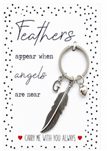 Remembrance memorial sympathy gift. A silver feather key ring with a letter 'G' initial and a small heart charm, presented on a white card with black polka dots and the text 'Feathers appear when angels are near' and 'CARRY ME WITH YOU ALWAYS'.