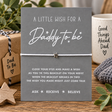 A 'Daddy to be' wish string bracelet set featuring a grey card with white text instructions, a white cord bracelet with a small star charm. Gift for a daddy to be. Father’s Day present for an expectant dad. 