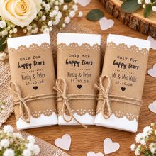 personalised wedding favour bags wrapped in white paper with lace trim and tied with twine