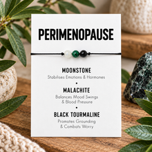 Perimenopause crystal bracelet. A small beaded cord bracelet displayed on a white card labeled 'PERIMENOPAUSE' with text for Moonstone, Malachite, and Black Tourmaline. The bracelet has three beads: moonstone, malachite and black tourmaline 
