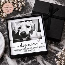 A personalized sterling silver necklace with a small heart charm is displayed in a black gift box alongside a printed photo of a dog and the text 'dog mom'. Dog mom Polaroid necklace 