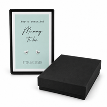 A pair of small silver heart stud earrings displayed on a mint green card inside a black gift box. Pregnancy gift for a mummy to be. Sterling silver heart stud earrings with gift box.