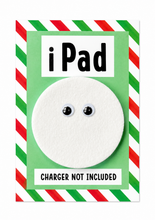 Joke iPad gift. A novelty product card featuring a white circular insert with two black-and-white plastic eyes, labeled 'iPad' at the top and 'CHARGER NOT INCLUDED' at the bottom, set against a green background with red and white diagonal striped borders.