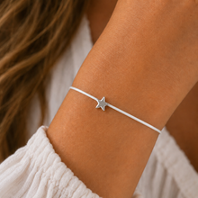 A delicate silver star charm bracelet on a thin white cotton cord. Star wish bracelet.