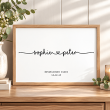 A framed personalized wall art print with the names 'sophie' and 'peter' connected by a small heart, plus the text 'Established since 14.02.