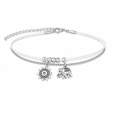 A double-strand silver anklet with a white cord and silver chain and a sun and elephant charm. White and silver double ankle bracelet. 