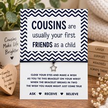 Cousins wish string bracelet. A square card with a black and white chevron border and printed message about cousins with a small star charm hanging from black cotton cord.