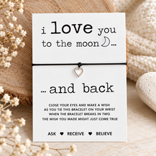 I love you to the moon and back wish string bracelet. A white card with black text reading 'i love you to the moon and back complete with silver heart bracelet 