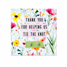 Silver knot earrings. A floral thank-you card with pink text reading 'THANK YOU FOR HELPING US TIE THE KNOT' holding two silver knot stud earrings. Wedding favours 