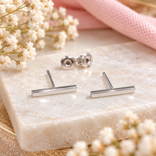 A pair of silver bar stud earrings with mouth backs 