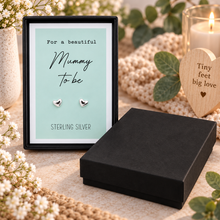 A pair of small silver heart stud earrings displayed on a mint green card inside a black gift box. Pregnancy gift for a mummy to be. Sterling silver heart stud earrings with gift box.